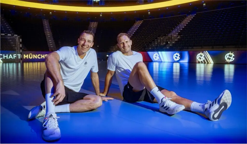 Dominik Klein und Steffen Weinhold sitzen gemeinsam auf dem Hallenboden vom SAP Garden